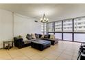 Cozy living room with large sectional sofa, tiled floor, and bright light at 5396 Gulf Blvd # 110, St Pete Beach, FL 33706