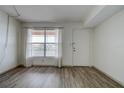 Bright living room showcasing new floors, a window, and a white front door at 6400 46Th N Ave # 307, Kenneth City, FL 33709
