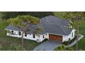 Aerial view of a modern home with a new gray roof, showcasing its architecture and spacious surroundings at 7425 245Th E St, Myakka City, FL 34251