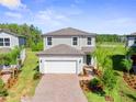 An aerial view showcasing a well-manicured lawn and a brick driveway of a charming two-story home at 10822 Windswept Garden Way, Tampa, FL 33647
