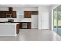 Modern kitchen with dark wood cabinets, stainless steel appliances, and a spacious island at 10822 Windswept Garden Way, Tampa, FL 33647