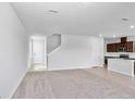 Bright, open-concept living area with plush carpeting seamlessly connected to the kitchen at 10822 Windswept Garden Way, Tampa, FL 33647