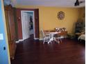 The hardwood floors extend from the living room past a doorway to the adjacent space at 10933 Subtle Trail Dr, Riverview, FL 33569