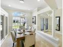Elegant dining room with modern lighting, a stylish table, and views of the front yard at 1123 Hounds Run, Safety Harbor, FL 34695