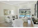 Bright living room with plush seating and sliding glass doors to a screened-in pool area at 1123 Hounds Run, Safety Harbor, FL 34695