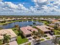 Aerial shot of a beautiful home with a pool and water view in a quiet neighborhood at 16206 Diamond Bay Dr, Wimauma, FL 33598