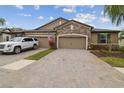 Well-maintained home exterior featuring a brick driveway and a stone facade, blending charm with modern design at 19317 Hawk Valley Dr, Tampa, FL 33647