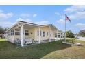 Inviting home featuring an American flag, covered porch, and well-maintained lawn at 35020 Colony Hills Dr, Zephyrhills, FL 33541