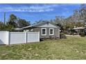 Back view of the home featuring well-maintained green lawn and a sturdy white fence adding privacy at 561 Park S St, St Petersburg, FL 33707