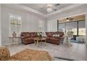 Bright living room featuring a comfortable leather sofa and stylish furnishings with access to lanai at 11563 Callisia Dr, Odessa, FL 33556