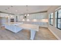 Bright kitchen features white cabinetry, stainless appliances, and a large marble-topped island with seating at 12779 Fisherville Way, Riverview, FL 33579