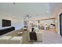 Open-concept living room showcases bright interior with kitchen, modern furniture, and sleek entertainment setup at 12779 Fisherville Way, Riverview, FL 33579