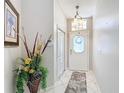 Inviting entryway with tile flooring, decorative floral arrangement, and a frosted glass front door for added privacy at 13252 Norman Cir, Hudson, FL 34669