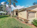 Lovely single-story house with a well-manicured lawn, a two-car garage, and a pathway leading to the front door at 13252 Norman Cir, Hudson, FL 34669
