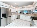 Bright kitchen featuring white cabinetry, stainless steel appliances, tile flooring, and ample counter space at 13252 Norman Cir, Hudson, FL 34669