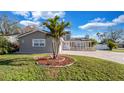 Charming single-Gathering home with well-kept lawn, beautiful palm tree, and paved driveway at 15701 Springmoss Ln, Tampa, FL 33624
