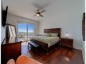Relaxing bedroom with a king-sized bed, ceiling fan and access to a private balcony with water views at 10 Papaya St # 1404, Clearwater Beach, FL 33767