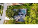 Aerial view showcasing a home with solar panels and a private pool with a screened enclosure at 16311 Colwood Dr, Odessa, FL 33556