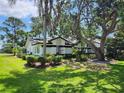 Well-maintained single Gathering home with lush landscaping, mature trees, and a beautiful green lawn at 16311 Colwood Dr, Odessa, FL 33556