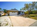 Charming single-story home featuring stone accents, a spacious driveway, and lush landscaping at 2838 Miriam S St, Gulfport, FL 33711