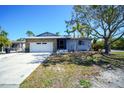 Charming single-story home featuring stone accents, a spacious driveway, and lush landscaping at 2838 Miriam S St, Gulfport, FL 33711