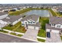 An aerial view of a two-story home with pond views in a residential neighborhood at 32346 Sapna Chime Dr, Wesley Chapel, FL 33545