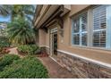Inviting home entrance with stone accents, a brick pathway, and lush landscaping at 650 Saxony Blvd, St Petersburg, FL 33716