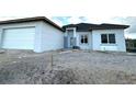 New construction home featuring a modern exterior with an attached garage and landscaping to be completed at 13224 Foresman Blvd, Port Charlotte, FL 33981