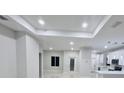Open-concept living area with modern lighting, leading to the kitchen, and tile floors at 13224 Foresman Blvd, Port Charlotte, FL 33981