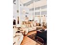 Open-concept living room with wood floors, vaulted ceilings, comfortable seating, and a view of the kitchen area at 200 Country Club Dr # 407, Largo, FL 33771