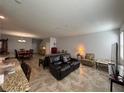 Open-concept living room with tile flooring, offering a seamless transition to the dining and kitchen areas at 20314 Starfinder Way, Tampa, FL 33647