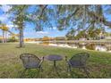 Relaxing backyard view with a table and chairs, overlooking a tranquil pond and lush greenery at 3830 Moreno Dr, Palm Harbor, FL 34685