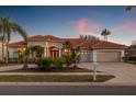 Charming home with a red tile roof, three-car garage, and lush landscaping at 3830 Moreno Dr, Palm Harbor, FL 34685