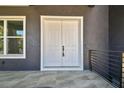 A close-up view of the double front doors with a gray exterior, and the gray tiling at 4406 W Euclid Ave, Tampa, FL 33629