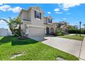 Side view of a charming two-story home with a well-manicured lawn and two-car garage at 7718 Landcare Ln, Tampa, FL 33616