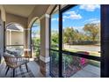 Comfortable screened front porch with decorative chairs, plants, and a neighborhood street view at 7718 Landcare Ln, Tampa, FL 33616