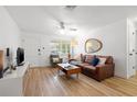 Inviting living room showcasing hardwood floors, comfortable seating, and natural light through the windows at 1230 7Th Ne Ave, Largo, FL 33770