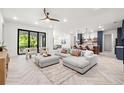 Bright, open-concept living room featuring a modern sectional, stylish decor, and beautiful herringbone floors at 1802 E Park Cir, Tampa, FL 33610