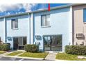 Exterior of the condo showing sliding glass doors and a small patio with green bushes at 1849 Abrico Dr # 4, Lutz, FL 33558