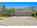 Charming single-story home featuring a three-car garage, lush landscaping, and a well-manicured lawn at 8205 Prairie Ridge Way, Tampa, FL 33647