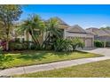 Charming single-story home featuring a three-car garage, lush landscaping, and a well-manicured lawn at 8205 Prairie Ridge Way, Tampa, FL 33647