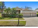 Charming single-story home featuring a three-car garage, lush landscaping, and a well-manicured lawn at 8205 Prairie Ridge Way, Tampa, FL 33647