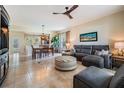 Open concept living room with large tile floors, modern ceiling fan, and neutral wall colors at 19308 Sunset Bay Dr, Land O Lakes, FL 34638