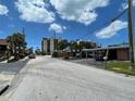 Charming street view of a quiet neighborhood with condominiums, lush trees, and street parking at 50 154Th Ave # 50, Madeira Beach, FL 33708