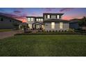 Beautiful home showcasing fresh landscaping, a brick driveway, and elegant exterior lighting at 7721 Roma Dune Dr, Wesley Chapel, FL 33545