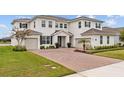 Charming two-story home boasts a brick driveway, three-car garage, and well-manicured lawn at 7721 Roma Dune Dr, Wesley Chapel, FL 33545