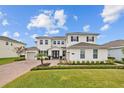 Beautiful home featuring manicured landscaping, brick driveway, and a two-car garage at 7721 Roma Dune Dr, Wesley Chapel, FL 33545