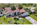 Inviting home featuring lush lawn, mature trees, and a wide driveway at 8208 Rhanbuoy Rd, Spring Hill, FL 34606