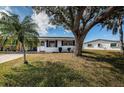 Charming single-story home with blue shutters, lush lawn, and mature trees on a sunny day at 10022 Lily N St # N, Pinellas Park, FL 33782