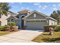 A single-story home with a two car garage, complemented by a well-maintained lawn and driveway at 18605 Le Dauphine Pl, Lutz, FL 33558